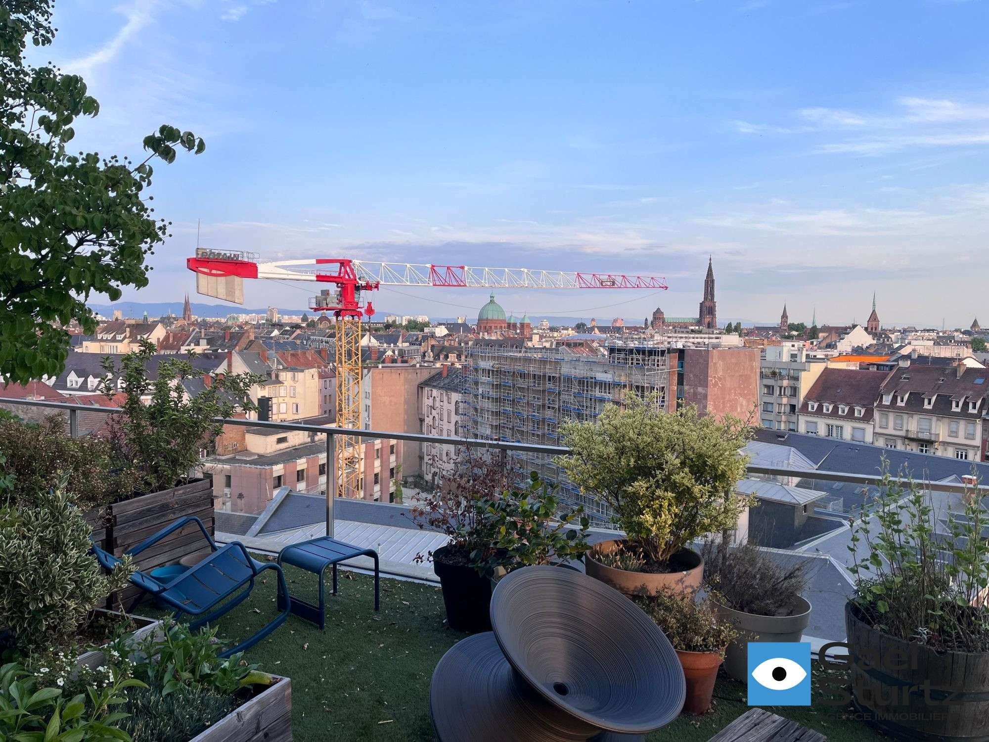 Photographie du panorama urbain depuis l’extérieur, avec une grue visible.