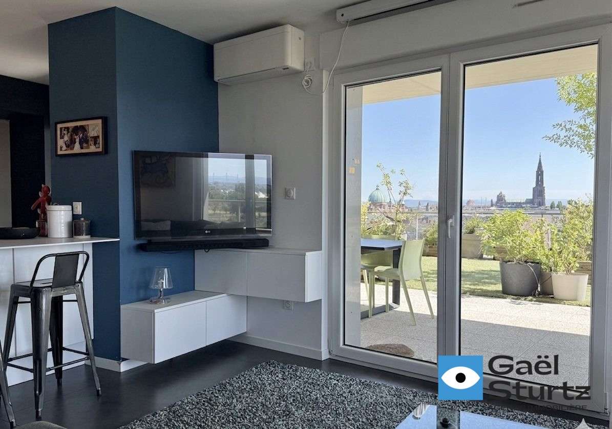 Vue intérieure vers une porte-fenêtre et la terrasse.